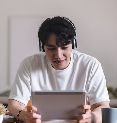 A learner wearing headphones and studying on a tablet